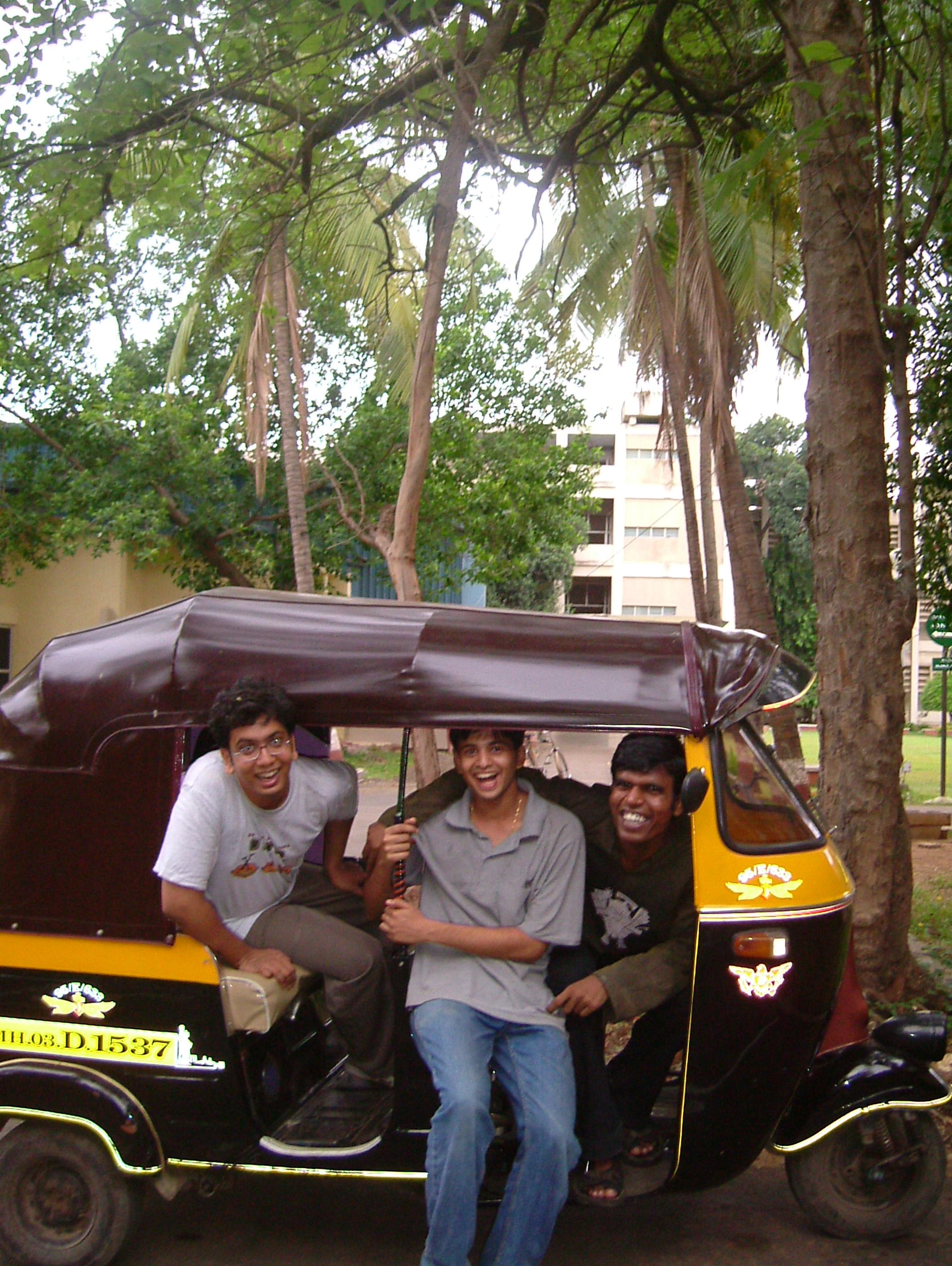 Three college friends riding together in an auto rickshaw