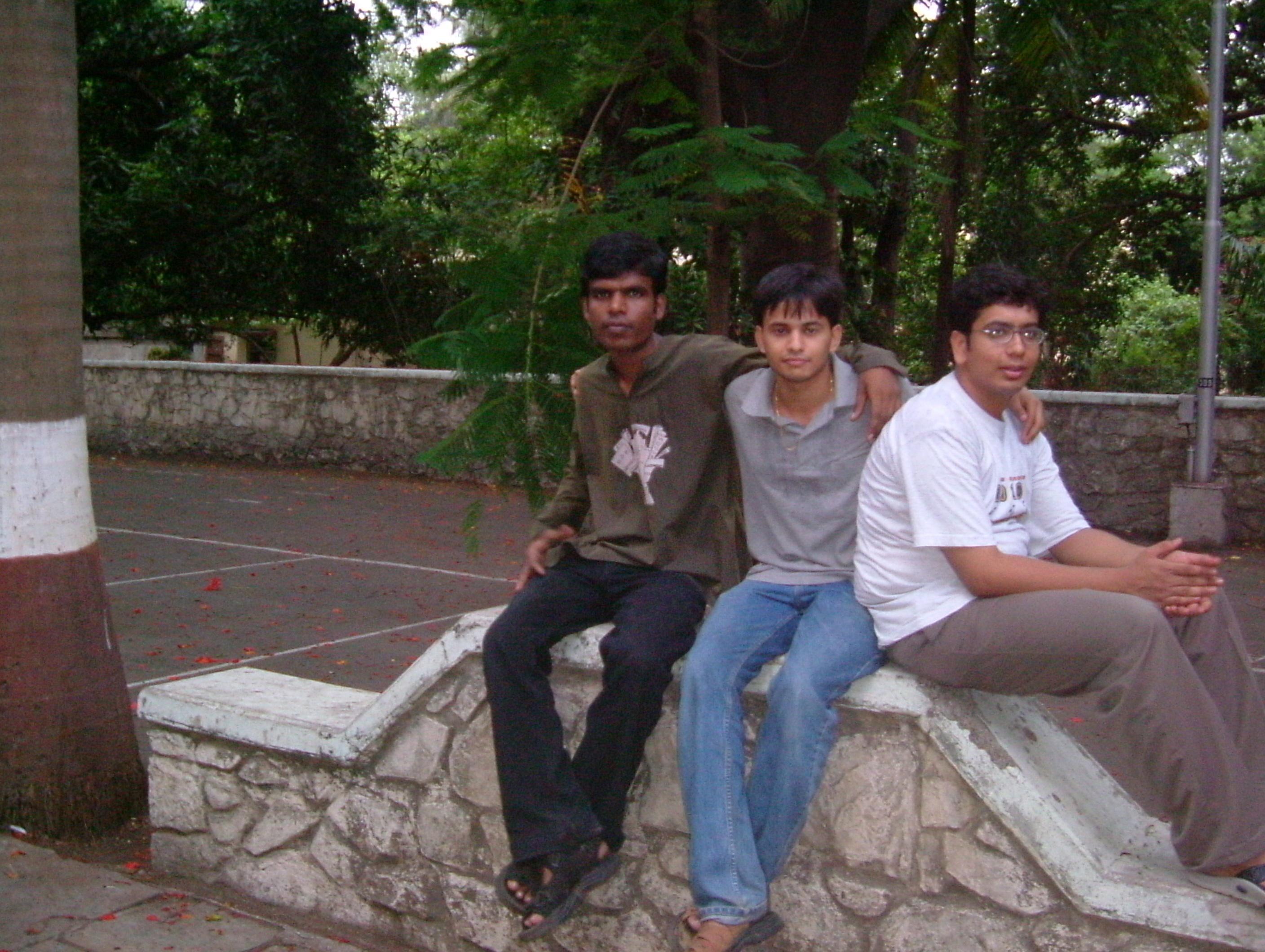 Three college friends sitting together outdoors near campus