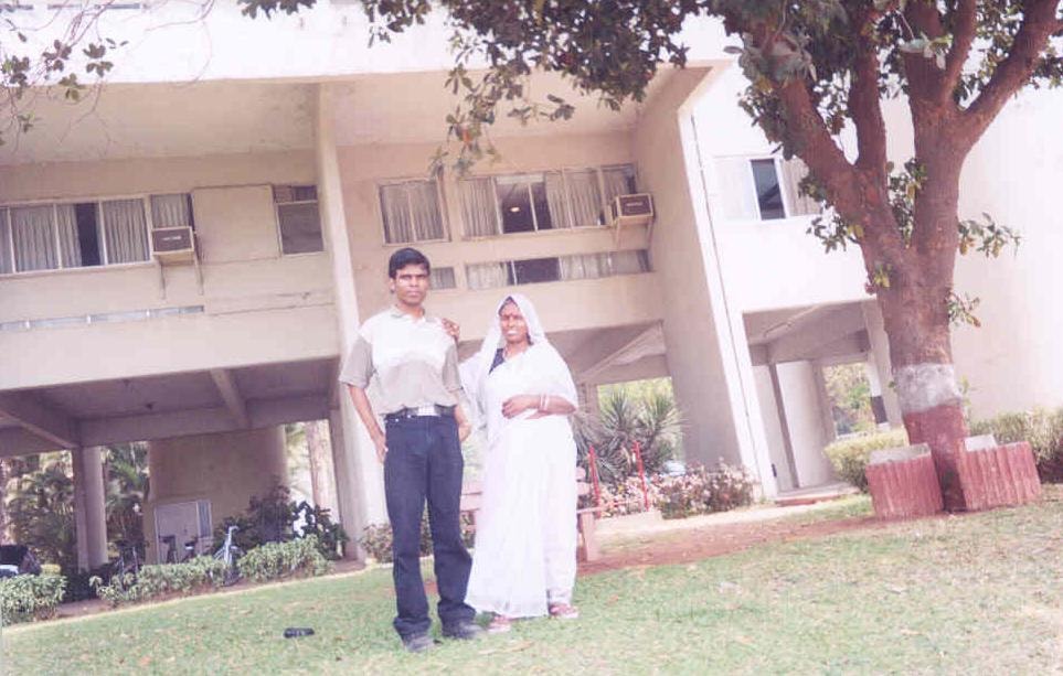 Pradeep Nagar's parents standing together on the IIT Bombay campus lawn