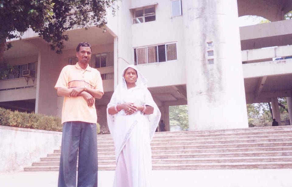 Pradeep Nagar's parents standing together outside an IIT Bombay building