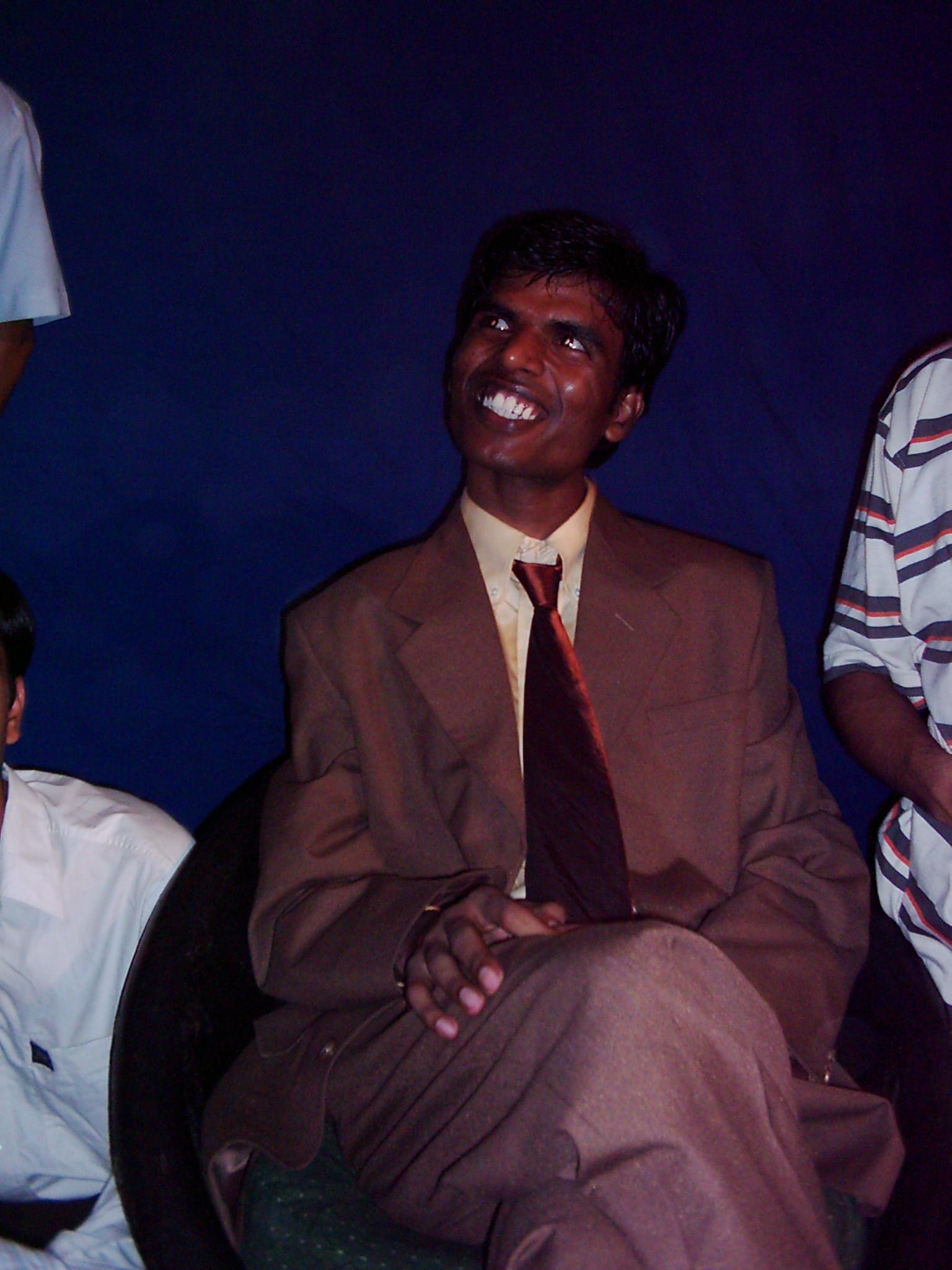Pradeep Nagar smiling in a suit at a college gathering