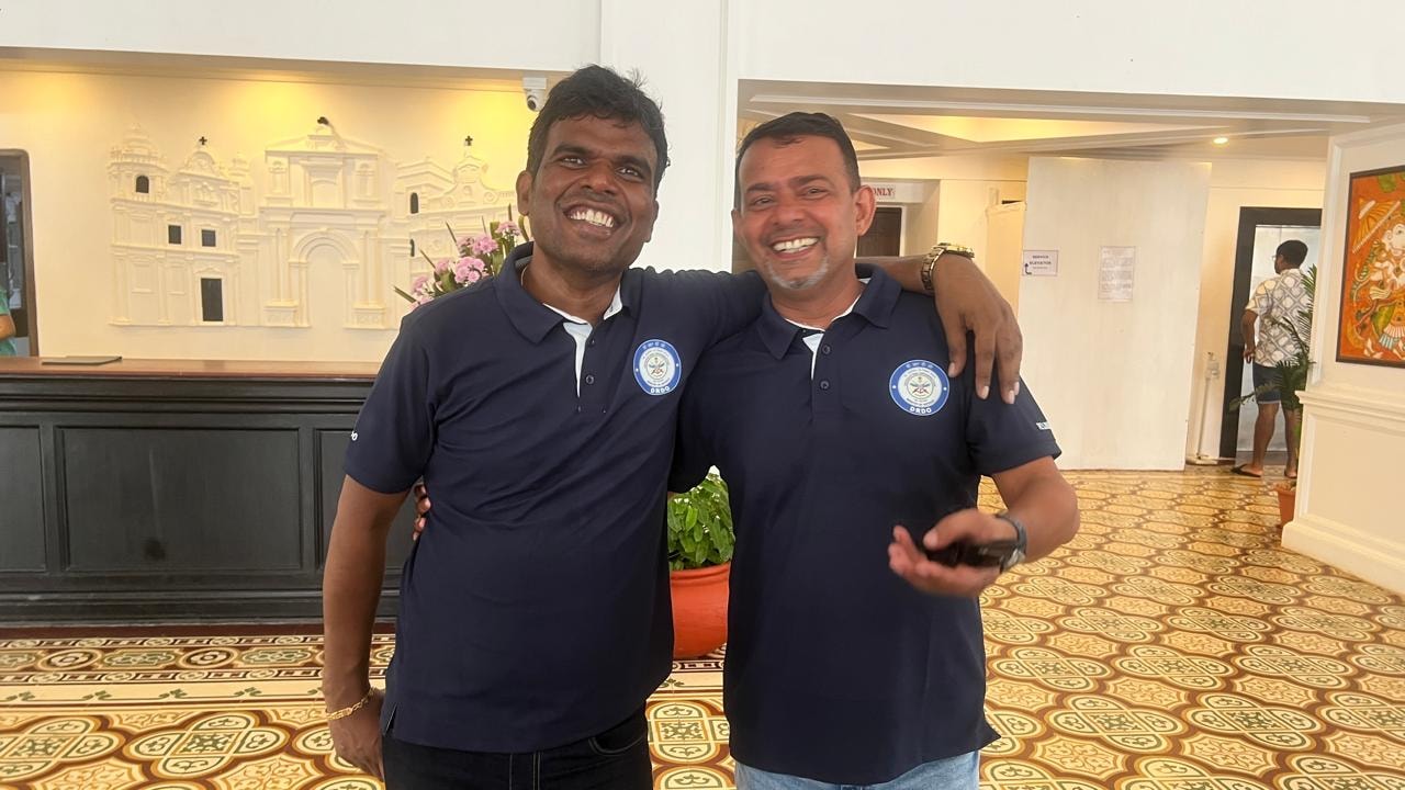 Two DRDO friends reconnecting at an indoor reunion