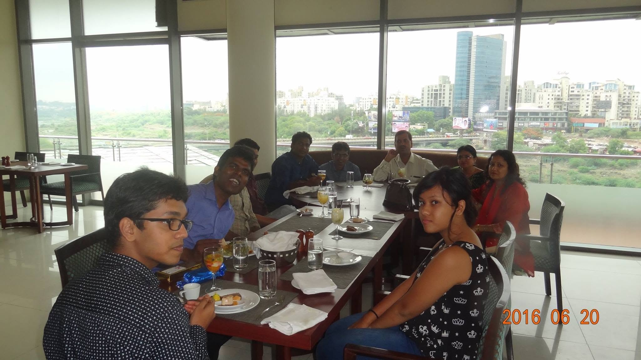 Friends gathered around a restaurant table with a city view