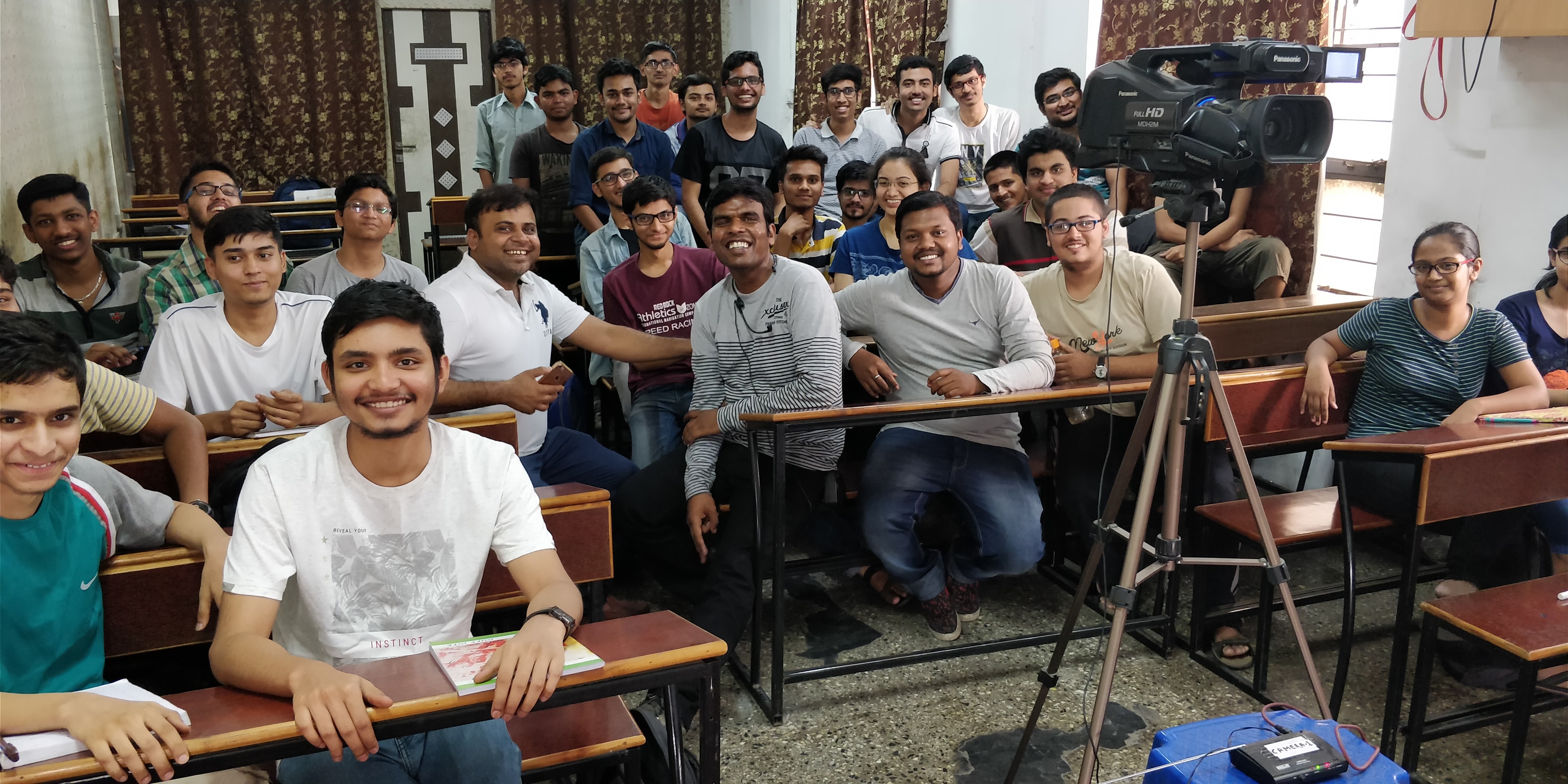 Students and instructors gathered in a classroom with recording equipment