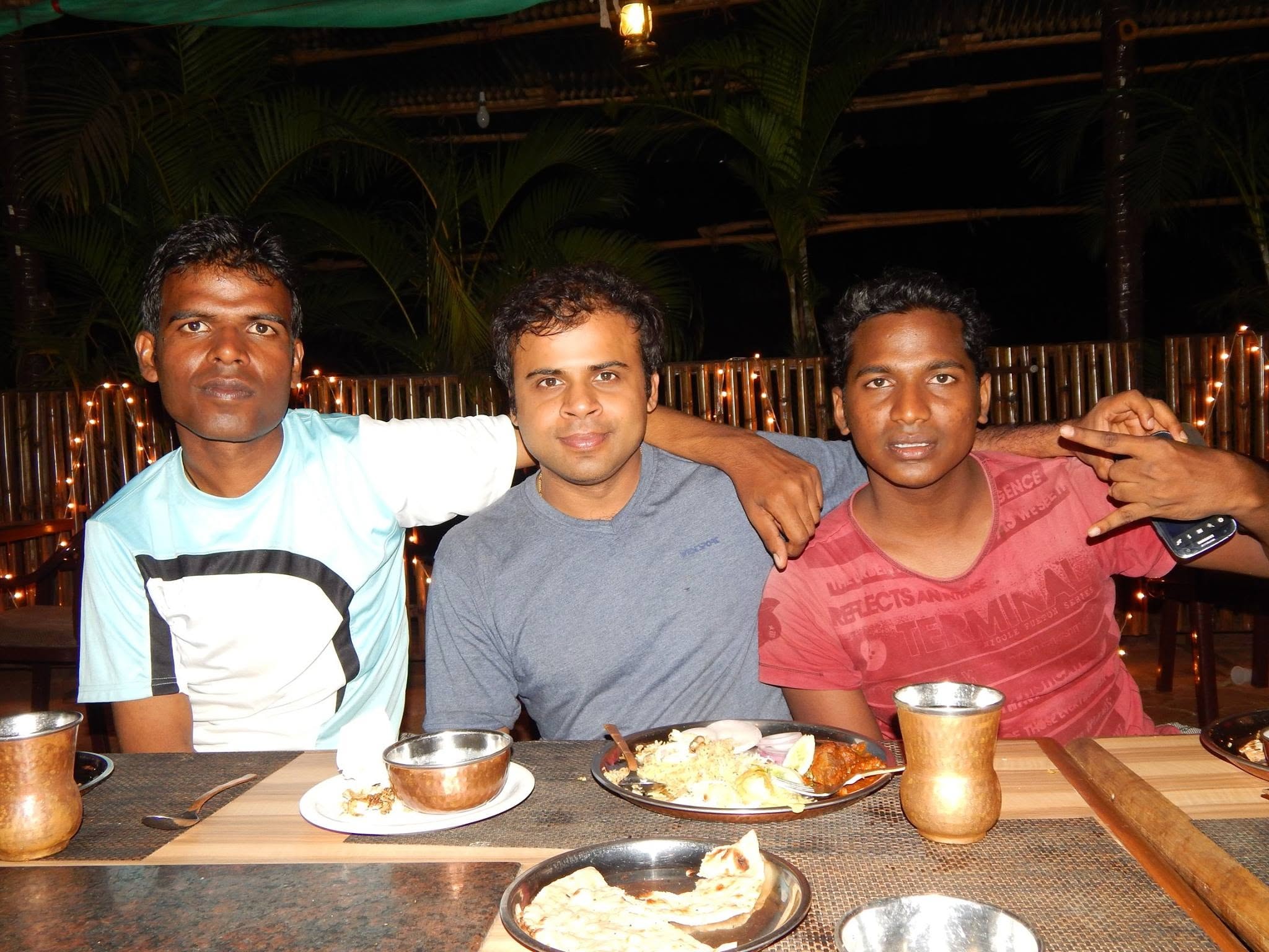 Three friends dining together at a warmly lit restaurant